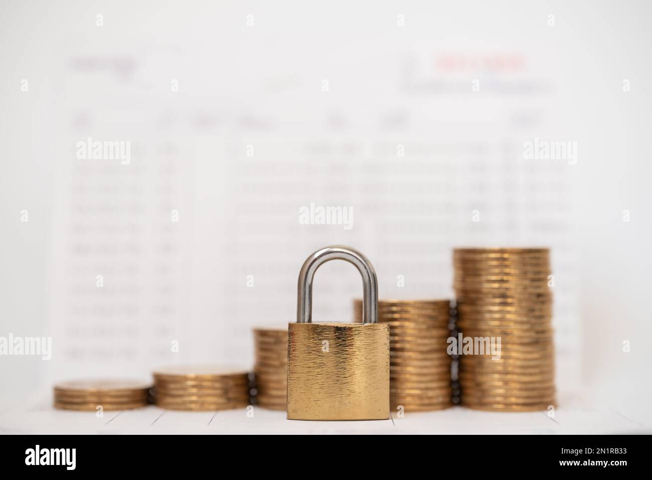 Money and Security Concept. Gold master key lock with stack of coins on bank passbook. Stock Photo