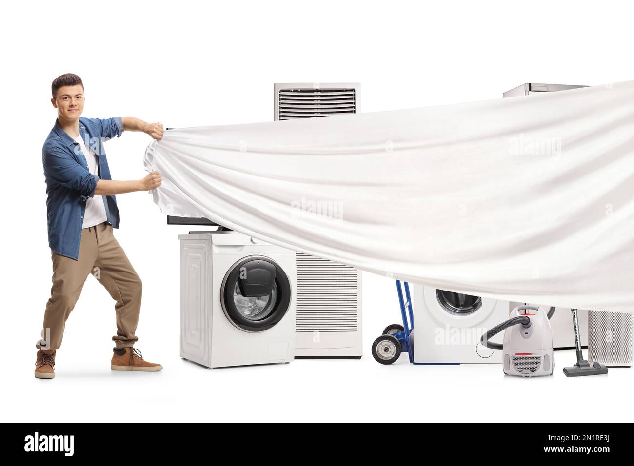 Young man pulling a white piece of cloth in front of home electrical appliances isolated on white background Stock Photo