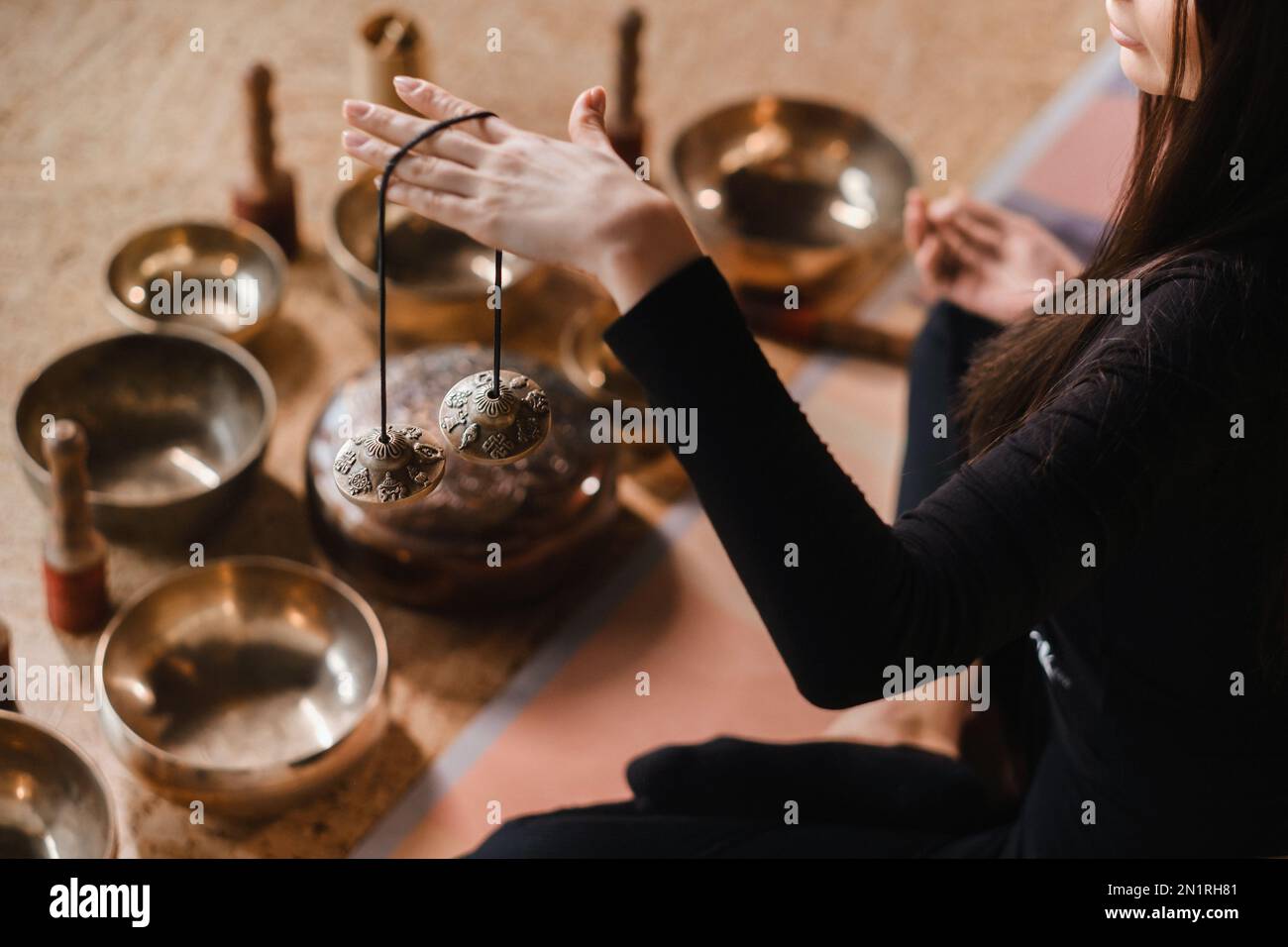 Closeup of a woman's hand holding Tibetan bells for sound therapy
