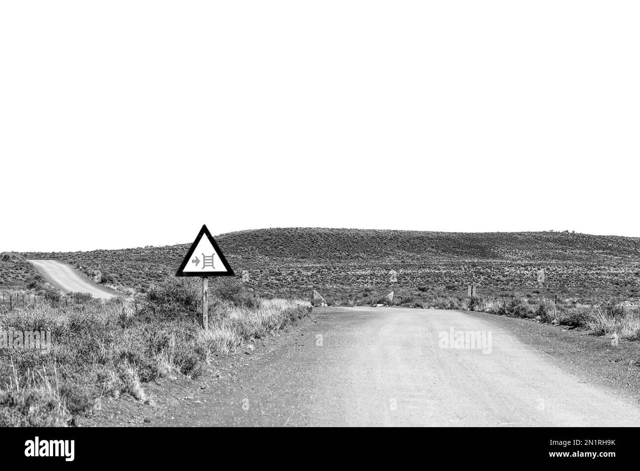 A landscape, with a cattle grid road sign, on road R356 between Loxton and Fraserburg in the Northern Cape Karoo. Monochrome Stock Photo