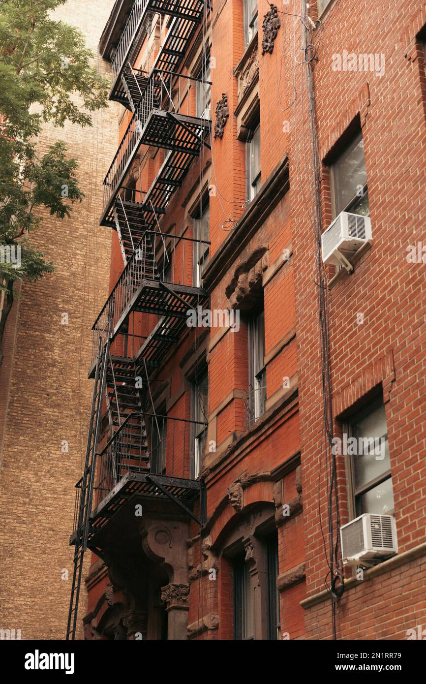 low angle view of brick building with metal balconies and fire escape