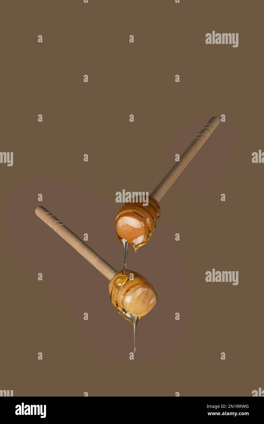 Honey dippers dripping with sweet sticky honey photographed against a