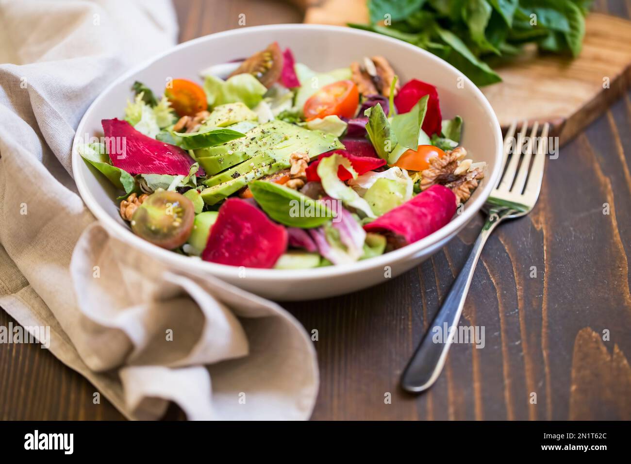 Fresh summer salad with avocado, lettuce , beet , nuts and seeds. Summer healthy vegan salad on wooden table, clean eating Stock Photo