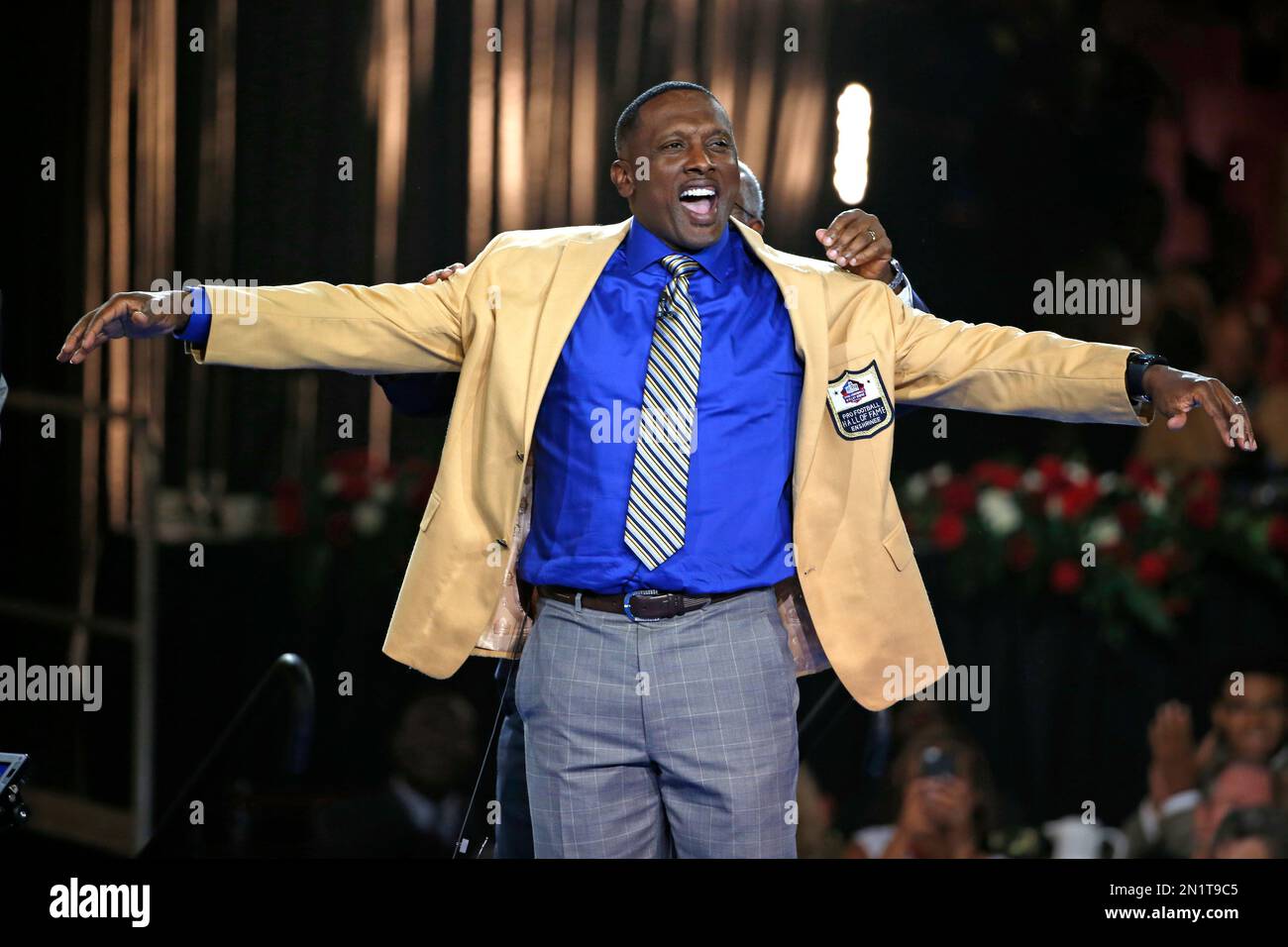 Pro Football Hall of Fame inductee Tim Brown slips on his gold jacket