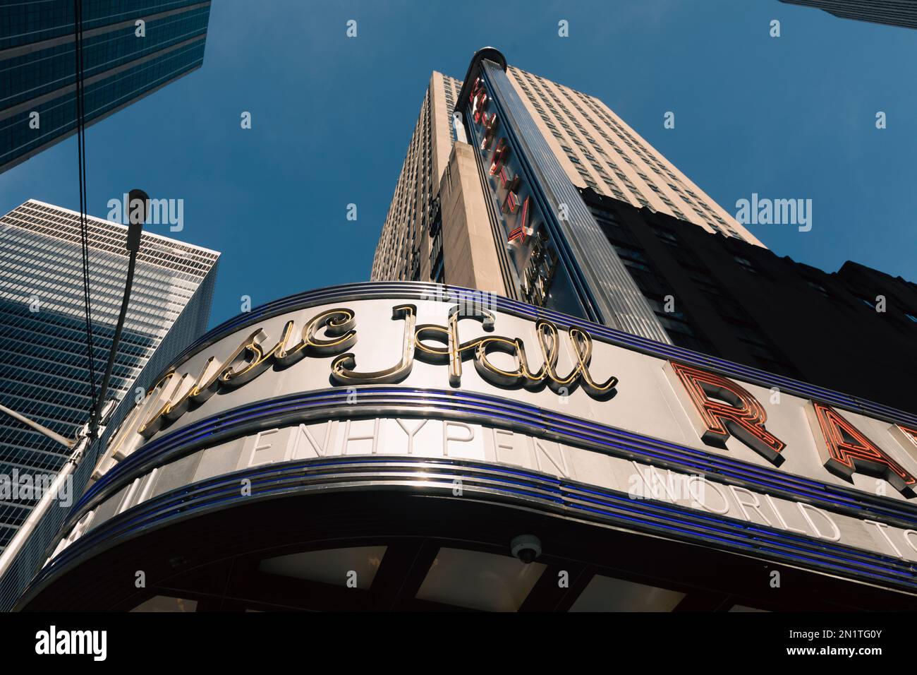 NEW YORK, USA - OCTOBER 13, 2022: low angle view of Radio City music hall and modern skyscrapers against blue sky Stock Photo