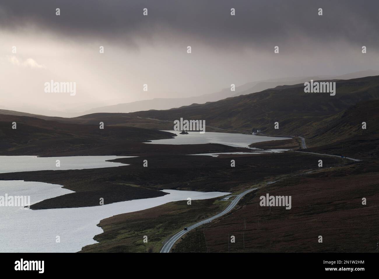 Car on the A855, which snakes around Loch Leathan and Loch Fada, Isle of Skye, Scotland Stock Photo