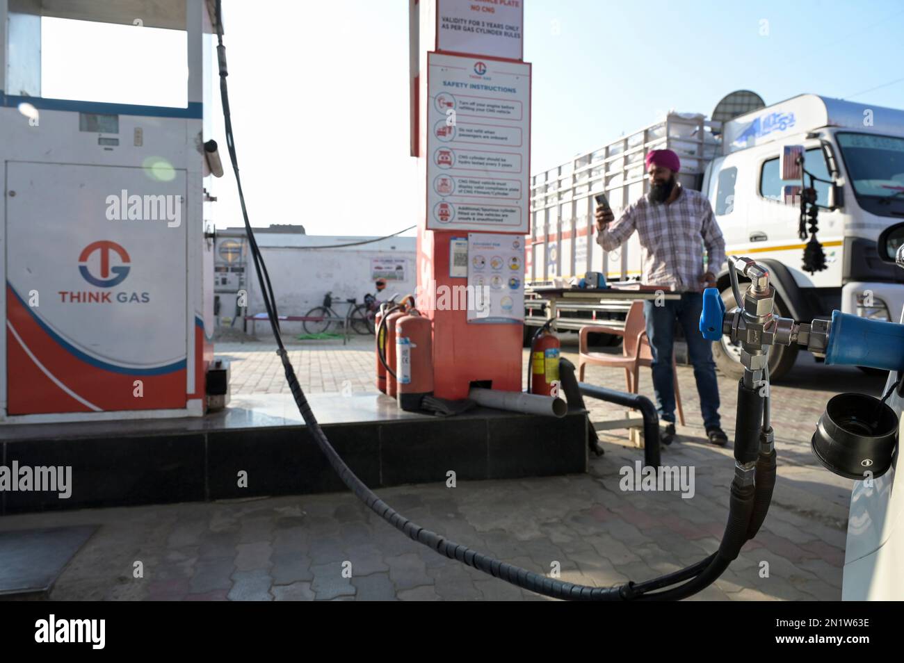 INDIA, Punjab, Think Gas CNG compressed natural gas fuel station, Maruti Suzuki car, Sikh man with mobile phone  / INDIEN, Think Gas Tankstelle für CNG komprimiertes Erdgas, Methangas Stock Photo