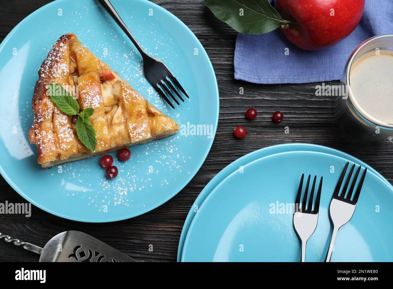 Slice of traditional apple pie served on black wooden table, flat lay Stock Photo