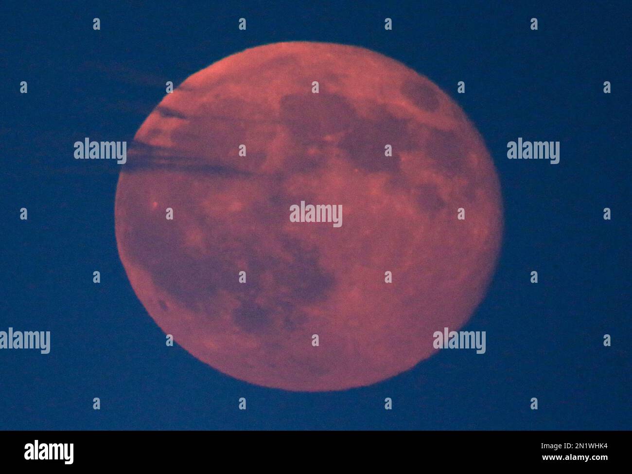 A blue moon is is diffused by clouds as it rises Friday, July 31, 2015 ...
