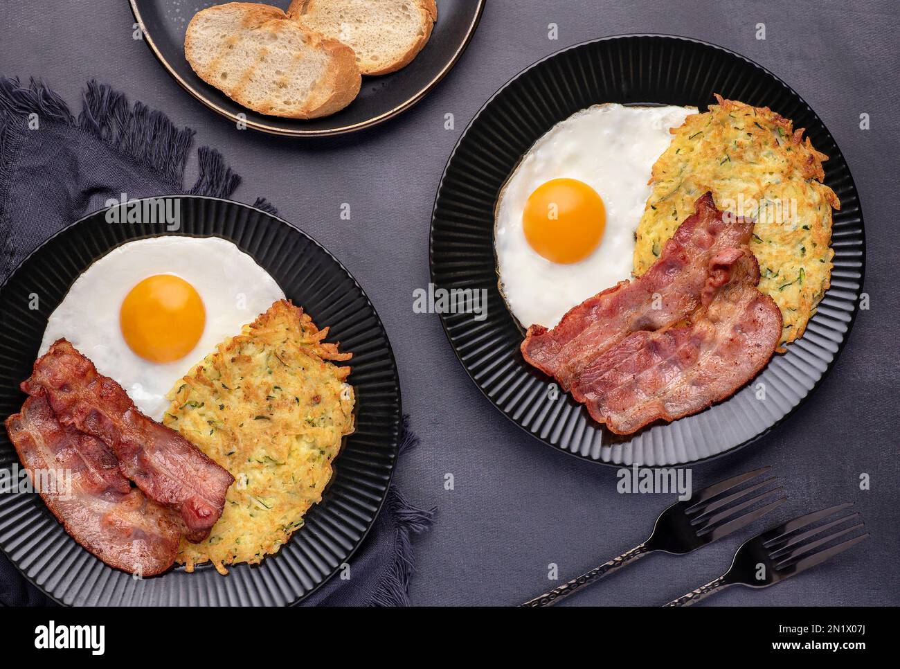 Food photography of fried egg, potato pancake, bacon, toast, brunch, breakfast Stock Photo