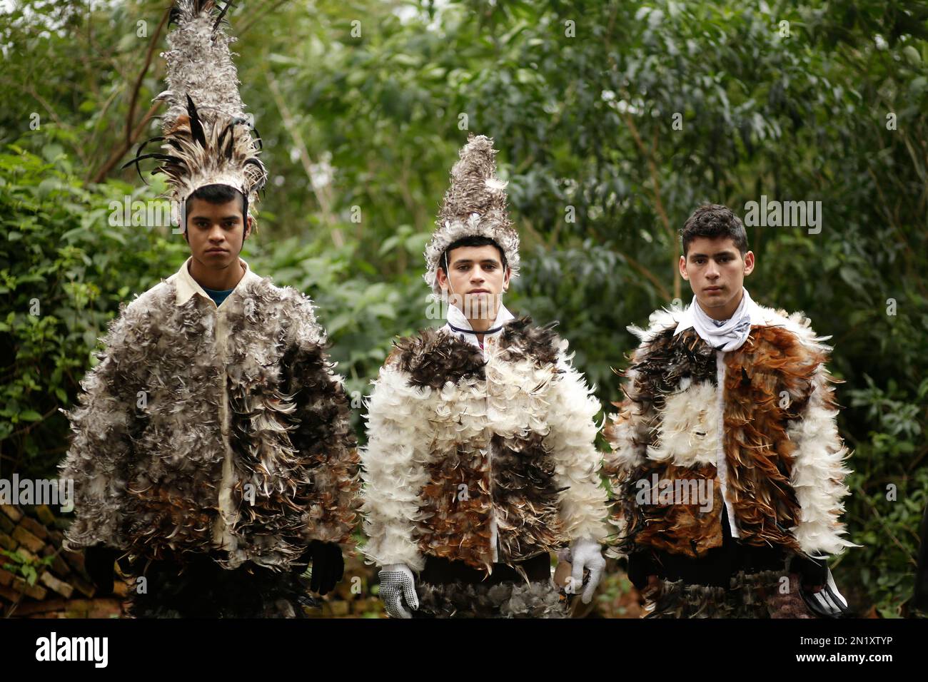 Catholic parishioners Hector Rafael Villaba, from left, Guillermo  Estigarribia, and his brother Jesus, pose in their bird-feather suits  during the feast day celebrations honoring St. Francisco Solano, in  Emboscada, Paraguay, Friday, July