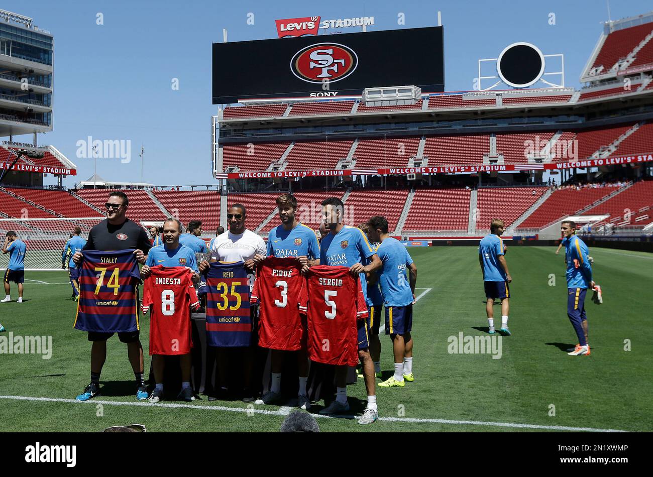 FC Barcelona soccer players Andres Iniesta, left, Gerard Pique, center, and  Sergio Busquets, right, hold up jerseys with San Francisco 49ers football  players Joe Staley, second from left, and Eric Reid during