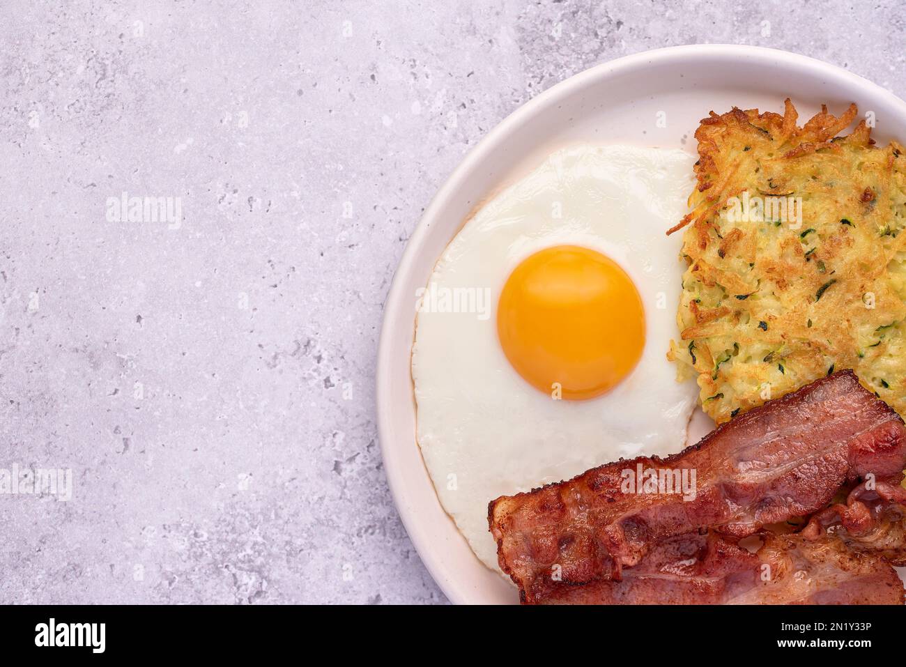 Macro food photography of fried egg, potato pancake, bacon, brunch, breakfast Stock Photo