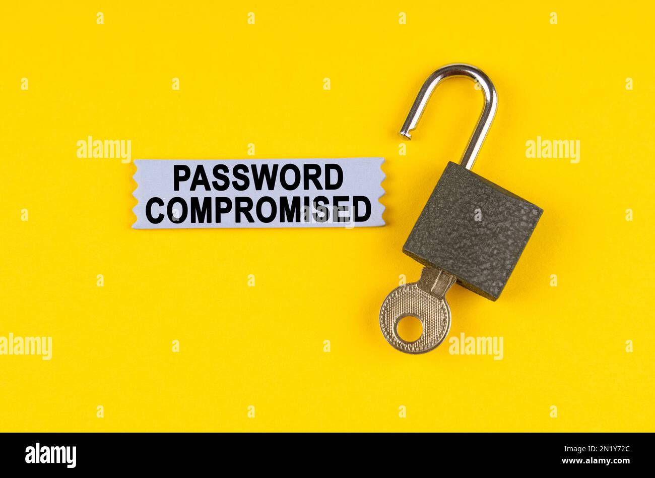 On the yellow surface lies an open lock with a key, next to it is a