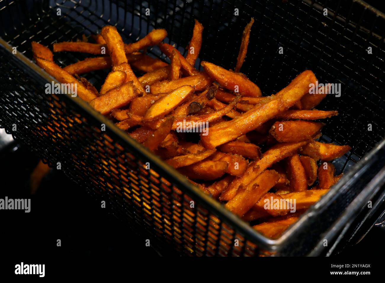 sweet potato french fries cooking in a deep fat fryer, fast food