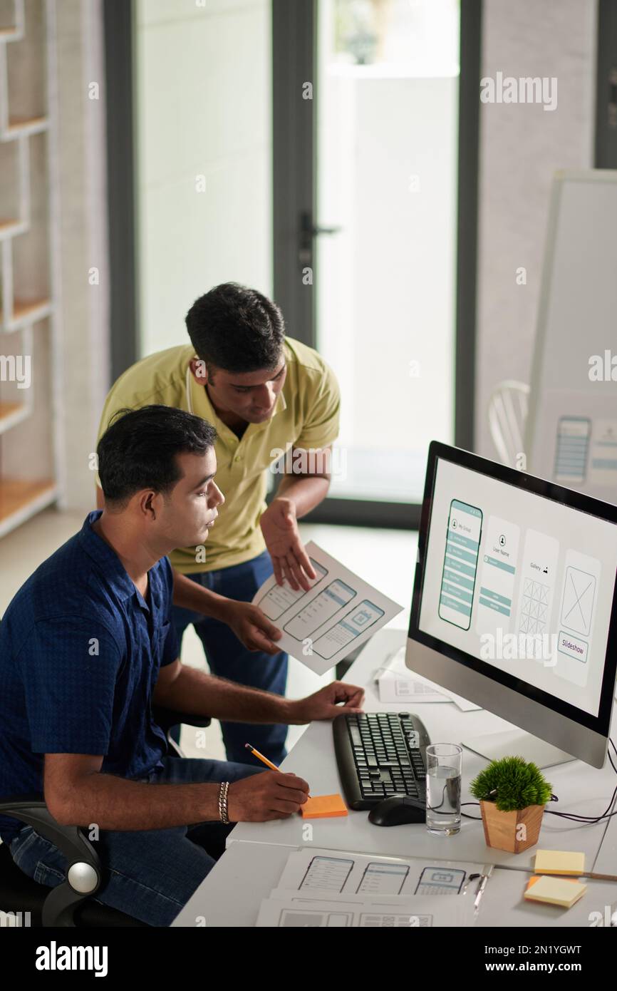 UI and UX designers discussing mobile application interface for new ...