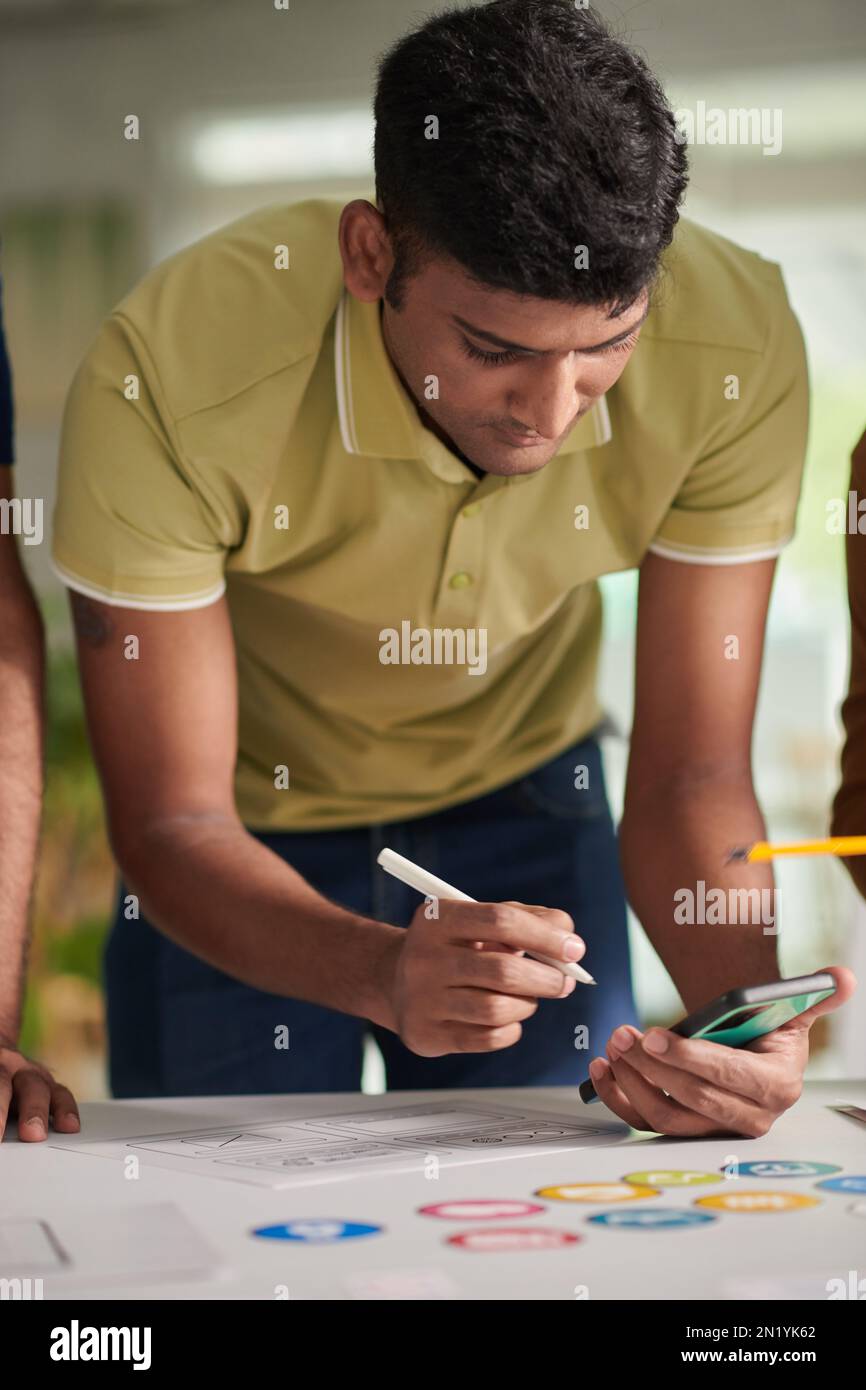Designer testing usability of mobile application on smartphone Stock Photo