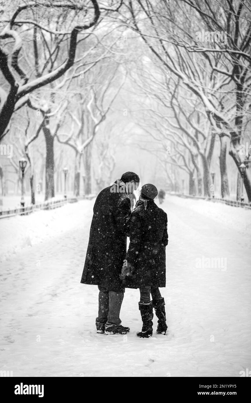 couple walking in the park during snow Stock Photo - Alamy