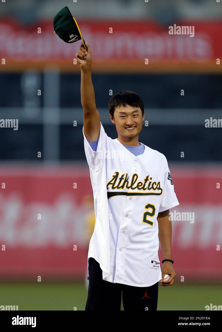 Golfer Hao Tong Li, of China, waves his cap prior to throwing out the ...