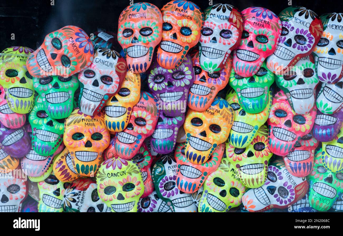 Small colorful smiling skulls with text written 'cancun, mayan riviera.' Souvenirs displayed for sale to tourists. Stock Photo
