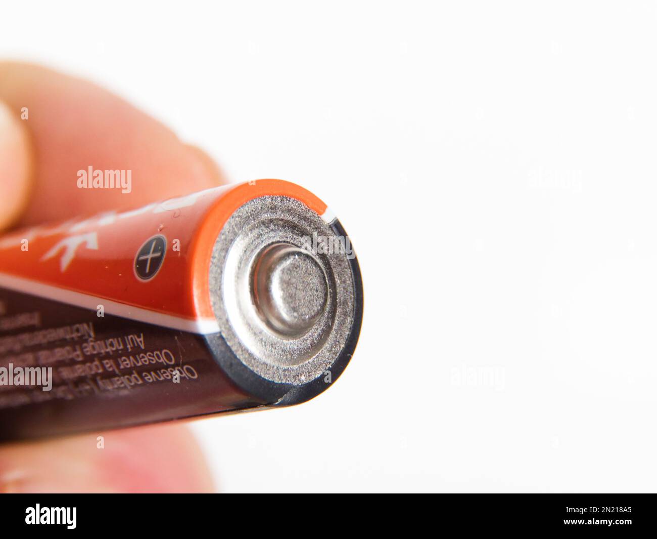 orange battery in hand. on a white background, close-up Stock Photo