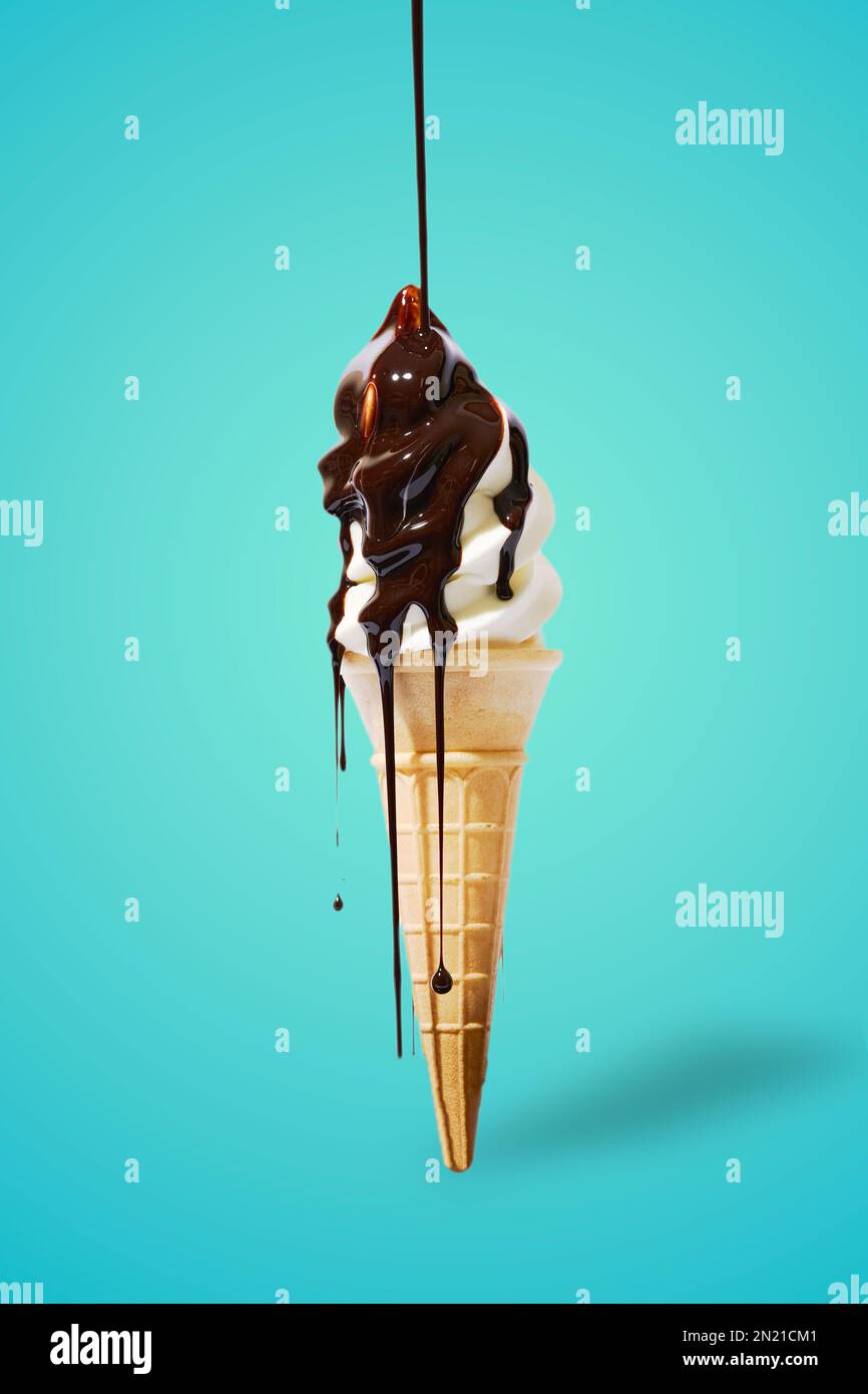 A vertical shot of an icecream cone with chocolate dripping on a blue ...