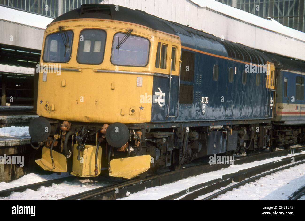 Ready to plough through the snow! True blue and immaculate Class 33 'Crompton' 33019 seen at London Waterloo on 1V11 the 11.10 Waterloo-Exeter service - taken 11th Feb 1991. Stock Photo