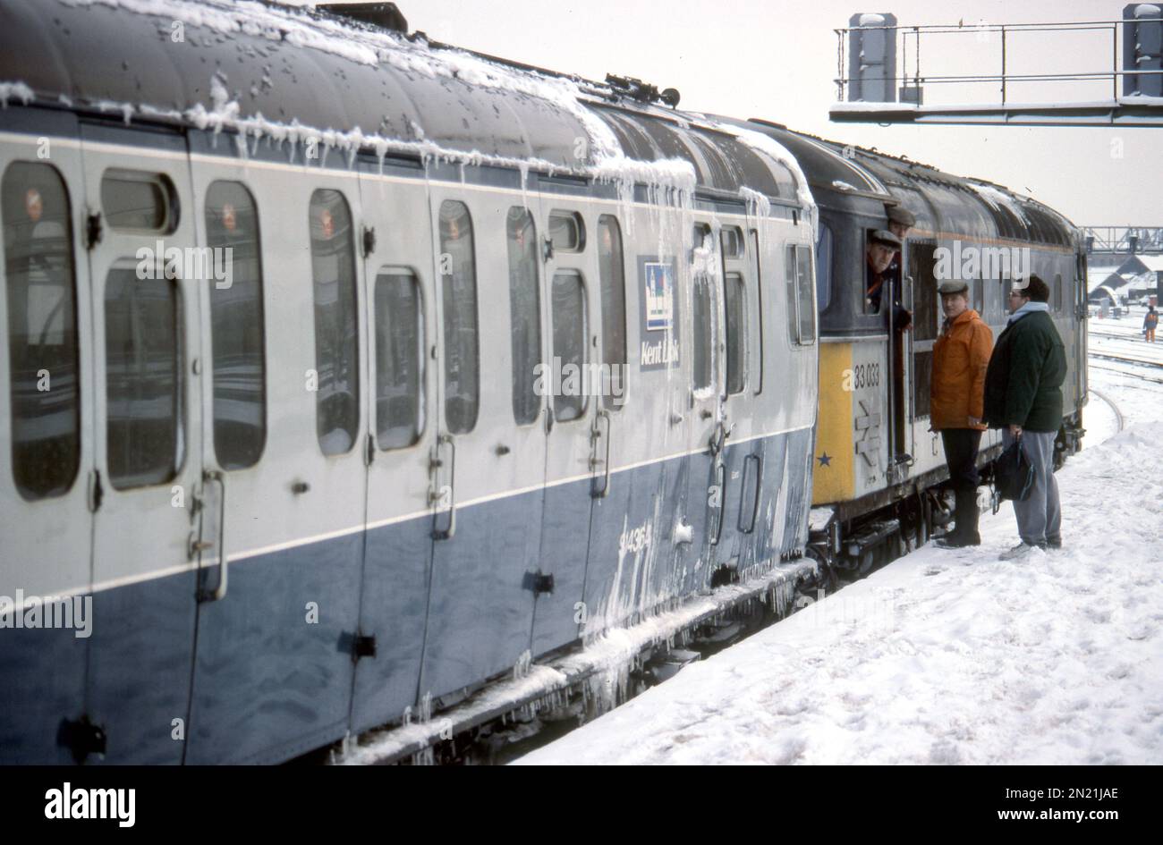 Three flat caps and a frozen scene at London Bridge station as Class 33 'Crompton' 33033 hooks up to a 4-EPB EMU, ready to drag the train back to Gillingham - taken on 9th Feb 1991. Stock Photo