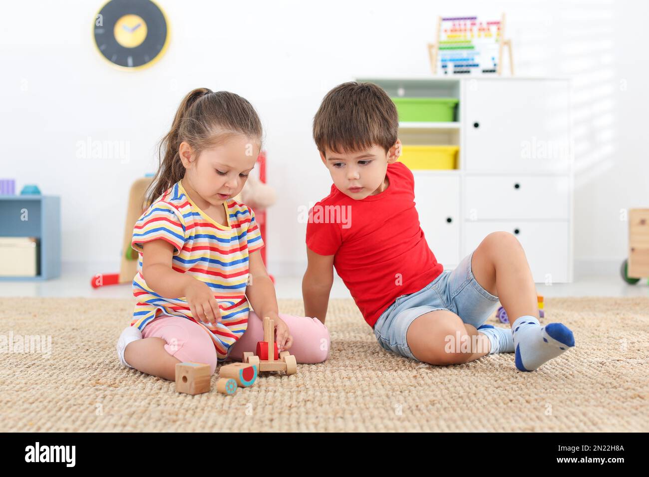 Cute little children playing with toys on floor at home Stock Photo - Alamy