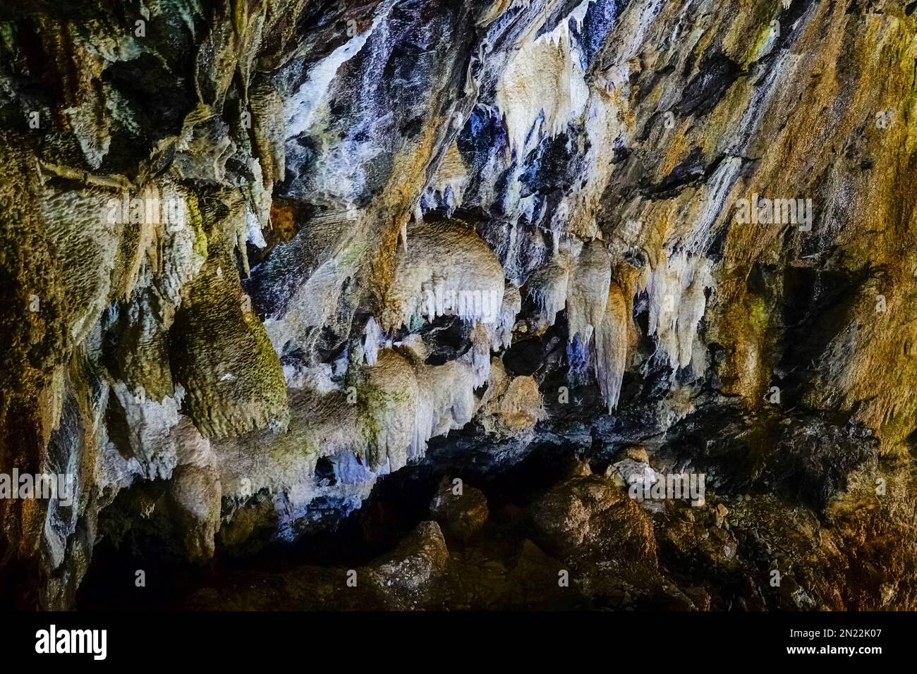 Silicate stalactites inside the Algar do Carvão a vertical lava tube dropping 300 feet from the surface accessible by a narrow staircase to a clear water pool at the bottom in the central mountains, Terceira Island, Azores, Portugal. Stock Photo