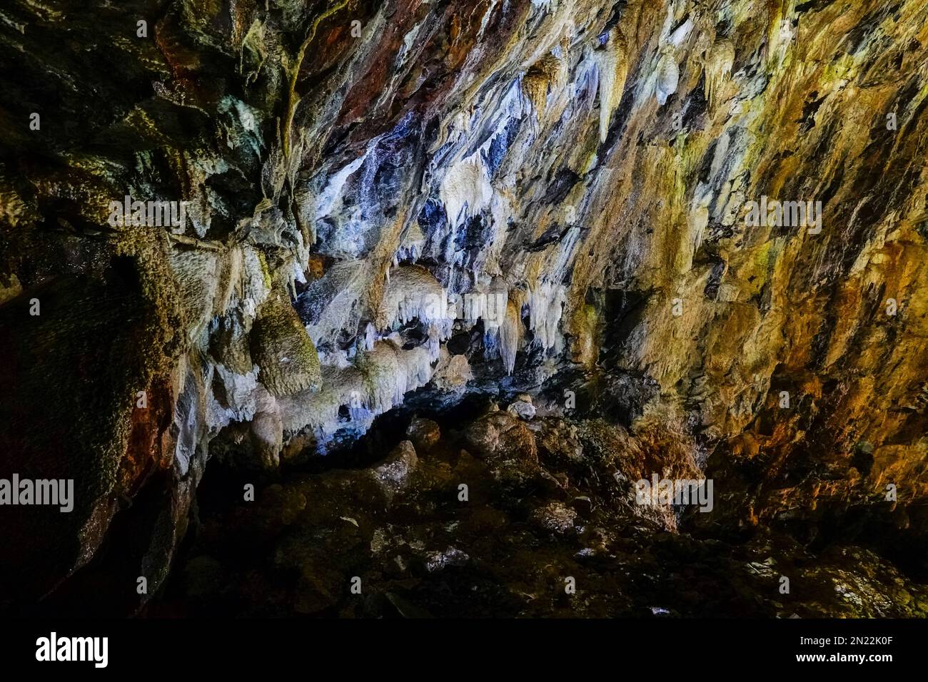 Silicate stalactites inside the Algar do Carvão a vertical lava tube dropping 300 feet from the surface accessible by a narrow staircase to a clear water pool at the bottom in the central mountains, Terceira Island, Azores, Portugal. Stock Photo