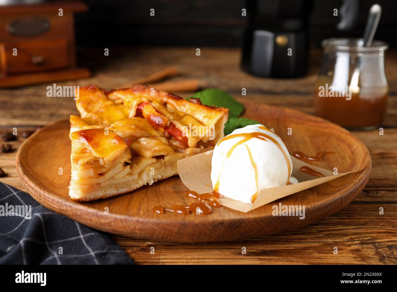 Slice of traditional apple pie with ice cream and mint on wooden table Stock Photo