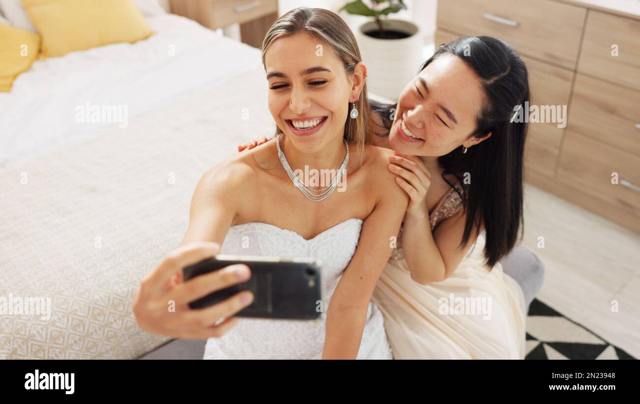 Bride, bridesmaid and selfie with phone, wedding and ring with a smile to post on social media. Happy woman and asian friend excited for marriage Stock Photo