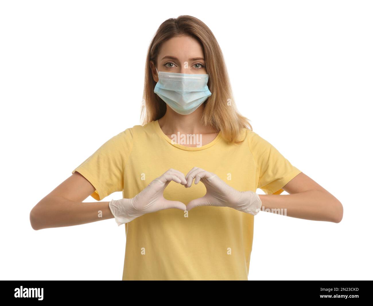 Young woman in medical gloves and protective mask making heart with ...
