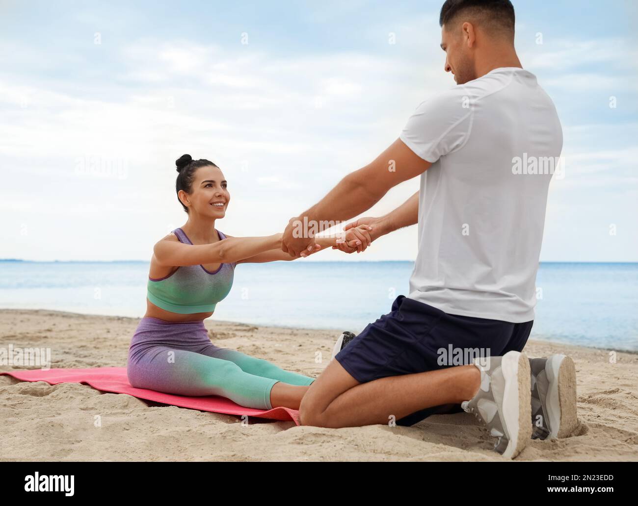 Couple doing exercise together on beach. Body training Stock Photo Alamy