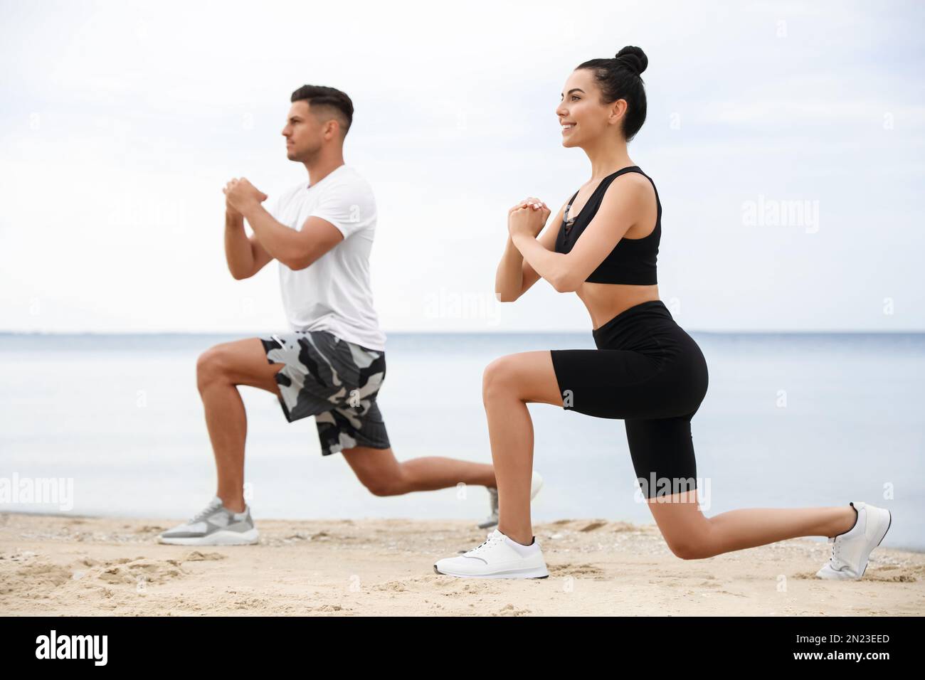 Couple doing exercise together on beach. Body training Stock Photo Alamy