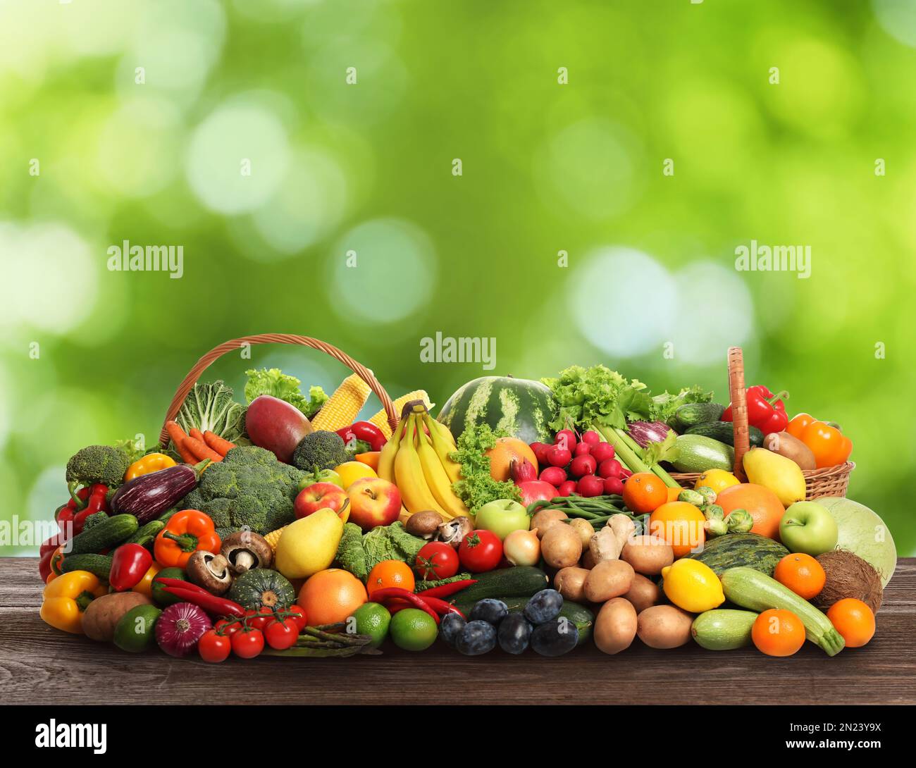 Assortment of fresh organic vegetables and fruits on wooden table ...