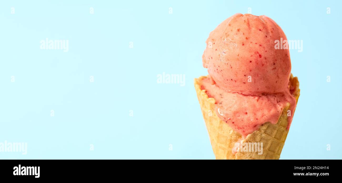 https://c8.alamy.com/comp/2N24H14/delicious-pink-ice-cream-in-waffle-cone-on-light-blue-background-closeup-space-for-text-2N24H14.jpg