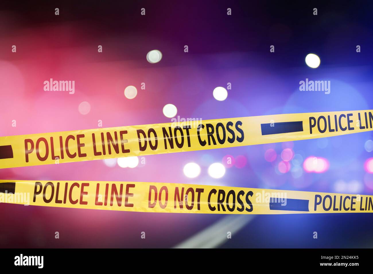 Yellow law enforcement tape isolating crime scene. Blurred view of city