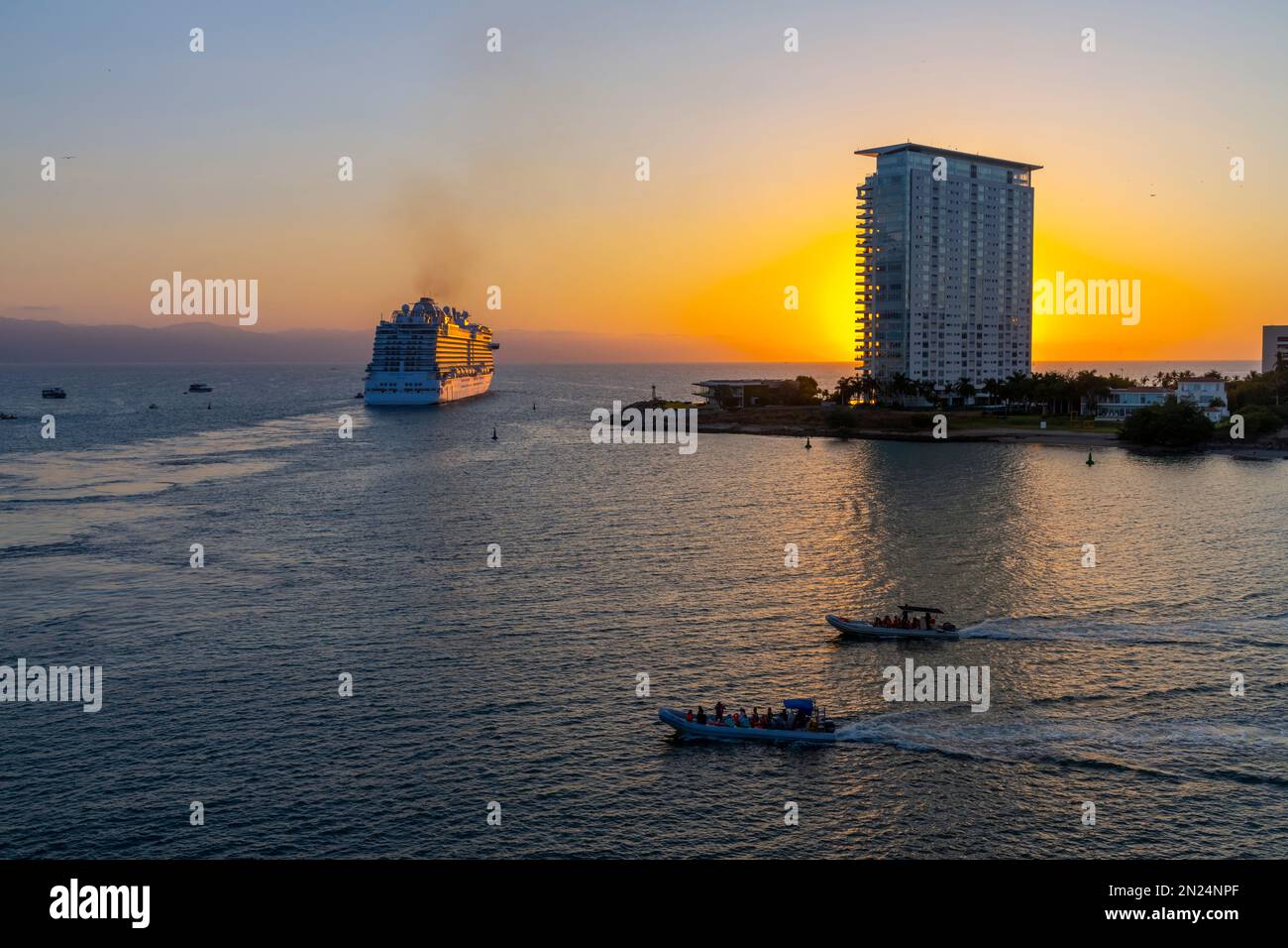 A large cruise ship heads out at sunset from the port of Puerto Vallarta, Mexico. Stock Photo