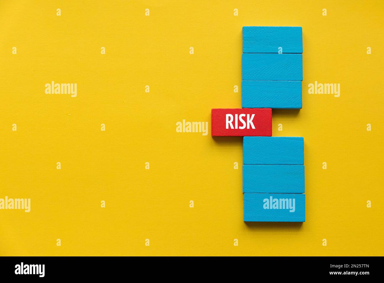 Risk concept. A stack of wooden block with a red wooden block come out in the middle. Stock Photo