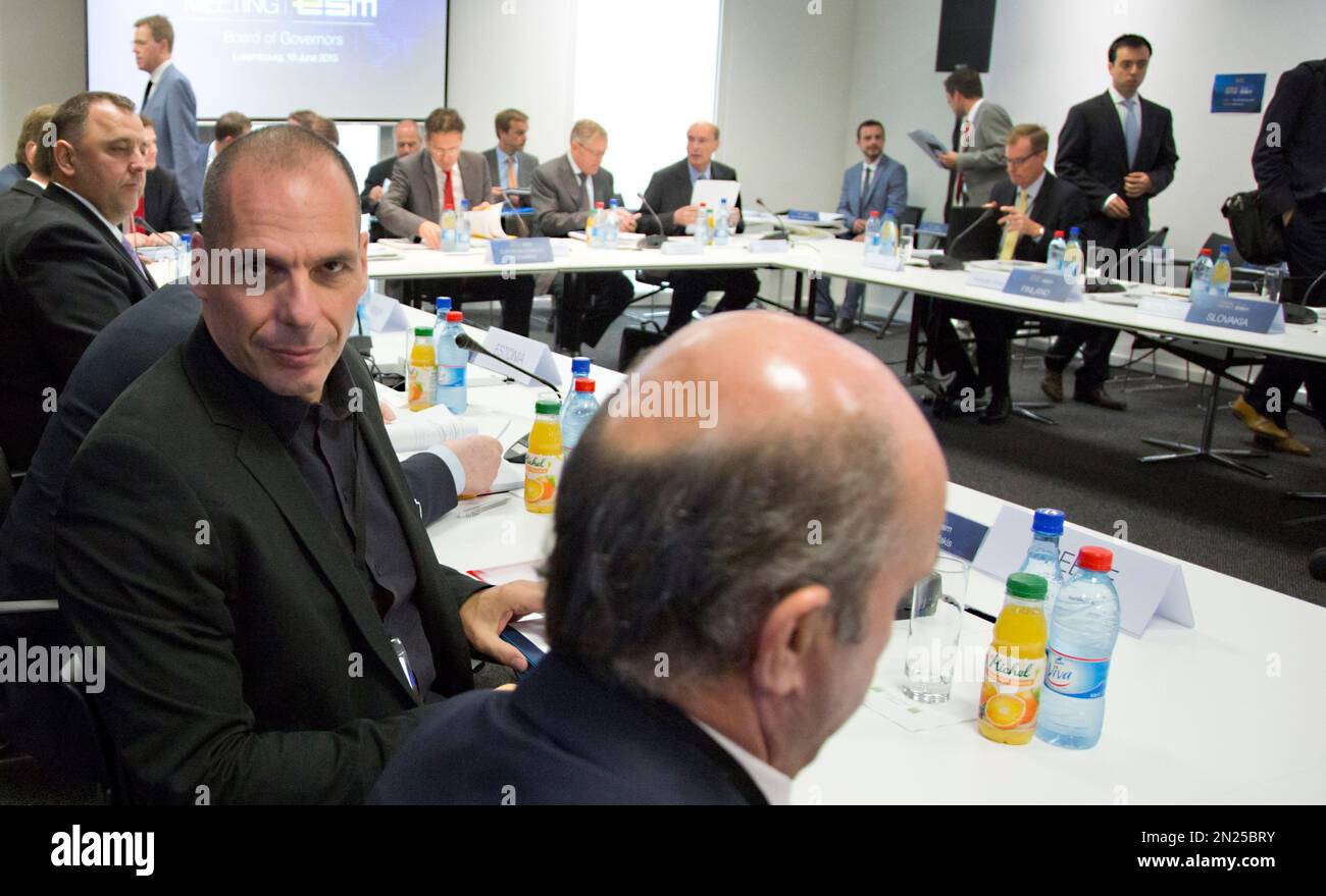 Greek Finance Minister Yanis Varoufakis, left, looks at the media as he  waits for the start of the annual meeting of the European Stability  Mechanism Board in Luxembourg on Thursday, June 18,