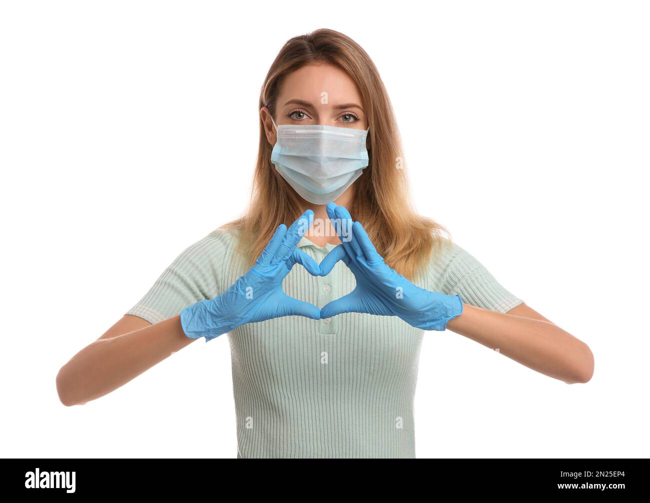 Young woman in medical gloves and protective mask making heart with ...