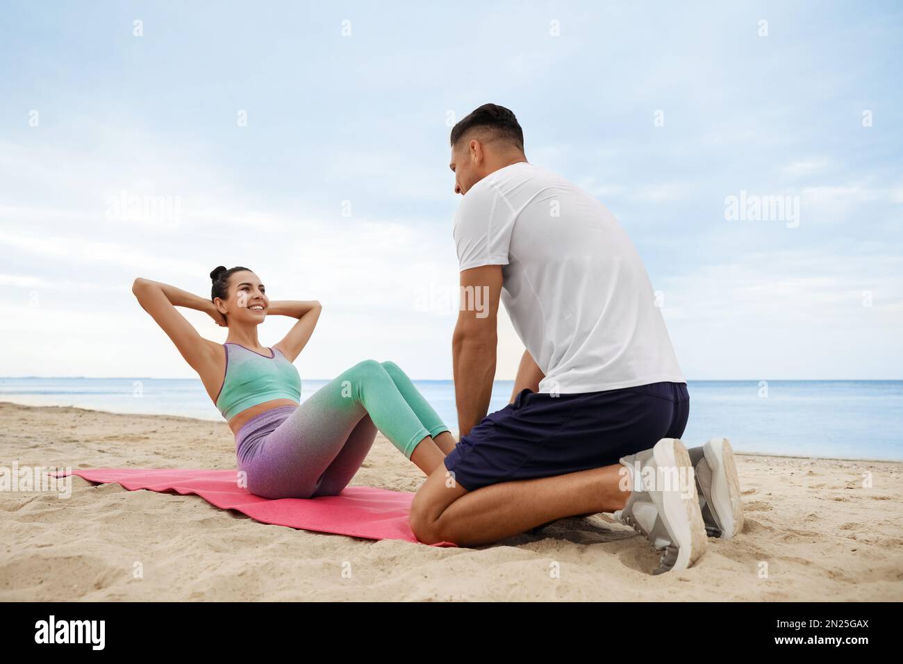 Couple doing exercise together on beach. Body training Stock Photo Alamy