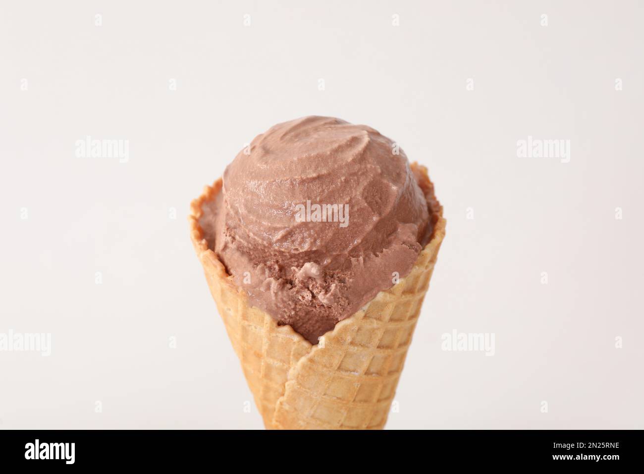 Delicious chocolate ice cream in waffle cone on white background ...