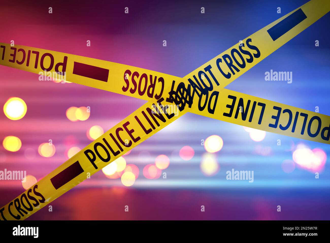 Yellow law enforcement tape isolating crime scene. Blurred background
