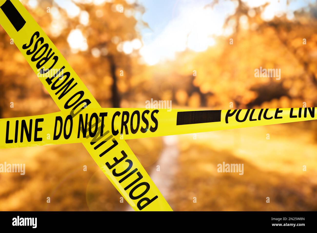 Yellow police tape isolating crime scene. Blurred view of autumn park Stock Photo Alamy