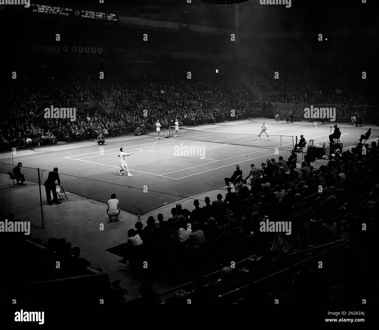 Professional champion Bobby Riggs, left, drives a forehand shot to