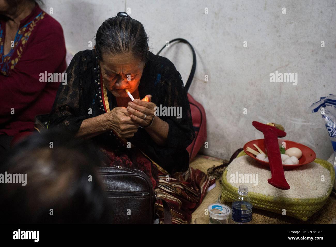 A spirit medium in trance lights a cigarette during an ancient ritual ...