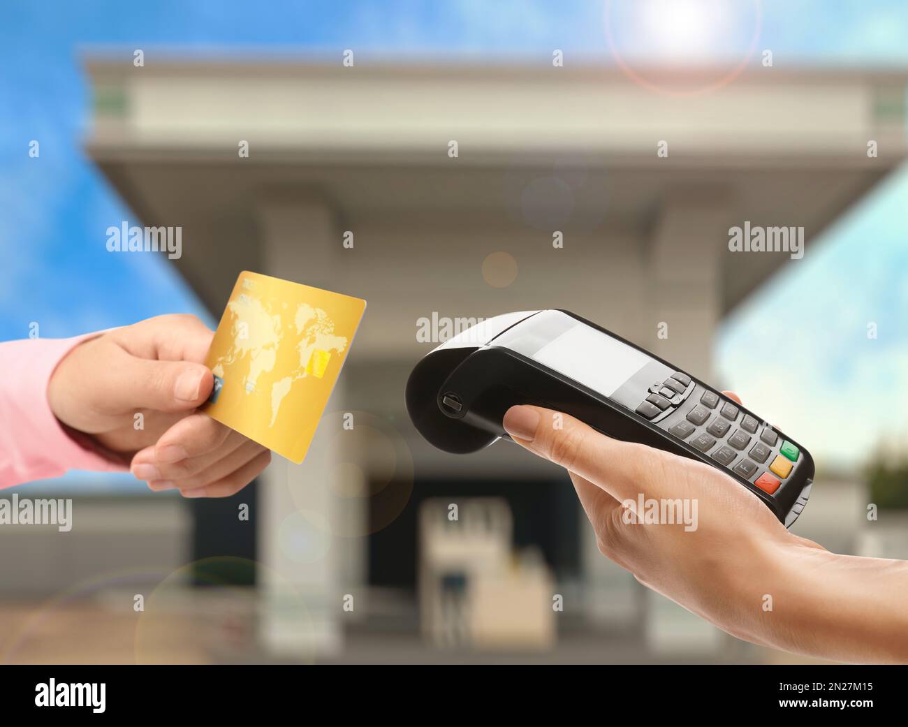 Woman paying for fuel using credit card via payment terminal at gas station, closeup Stock Photo